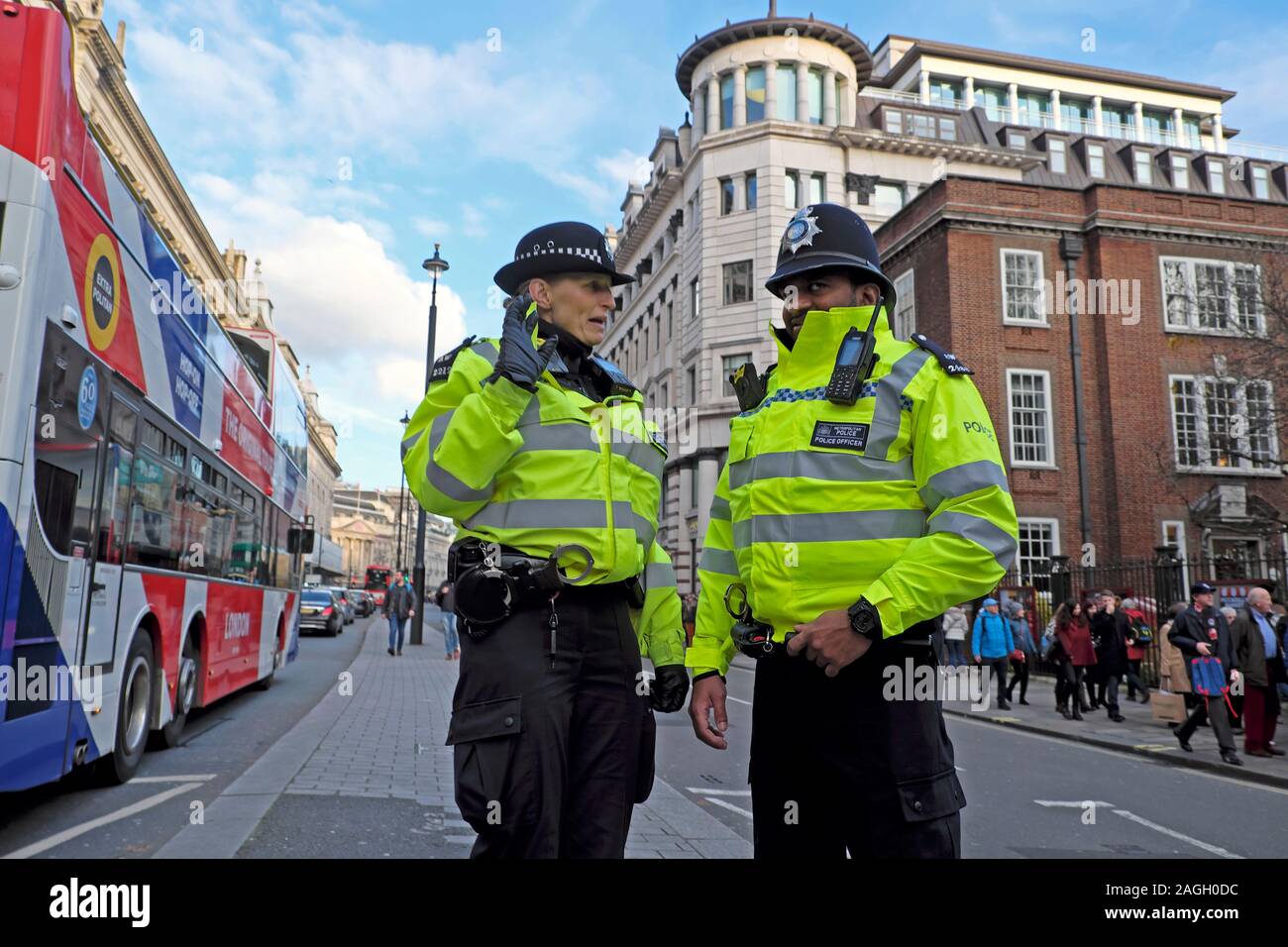 Policewoman and policeman talking in conversation standing in the road in Piccadilly Street near Fortnum & Mason West London England UK  KATHY DEWITT Stock Photo