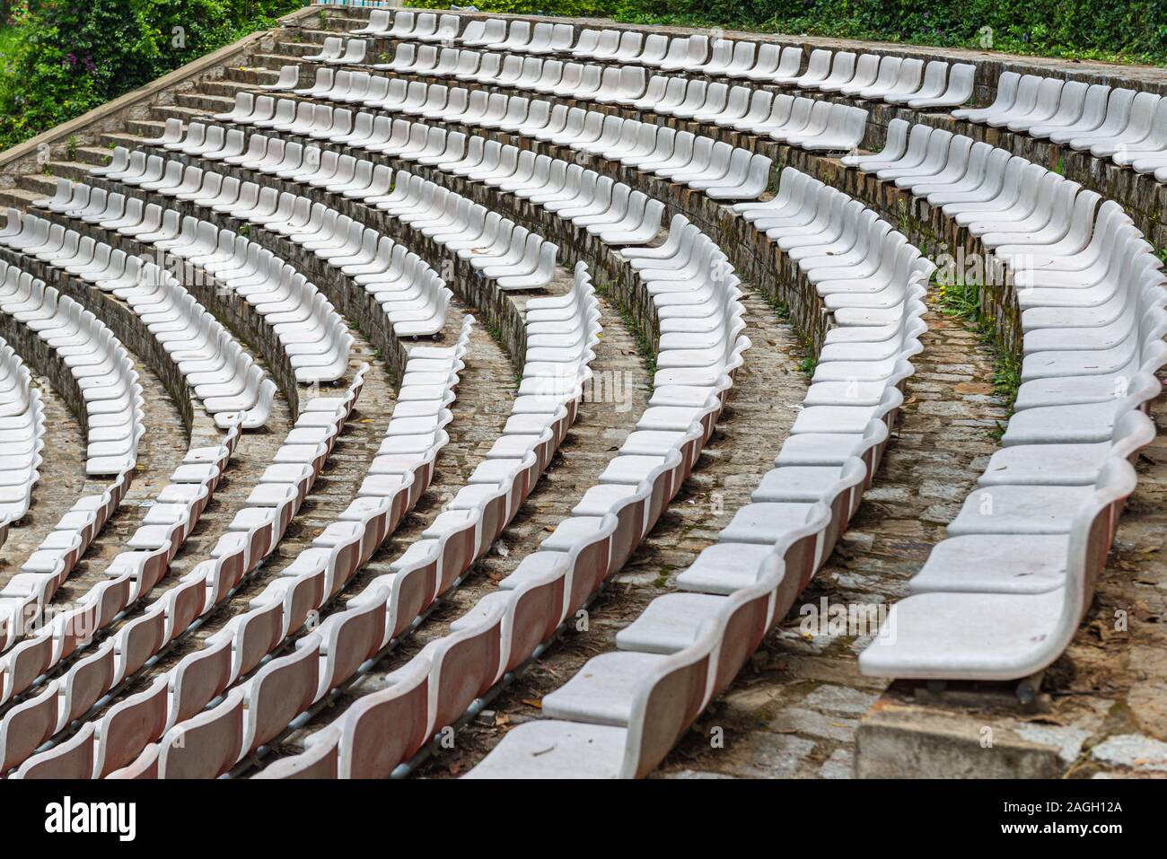 White plastic chairs in rows at outdoor stadium Stock Photo