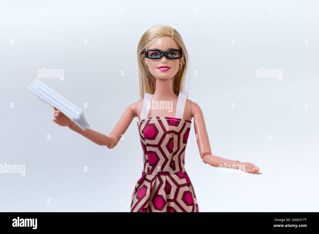 Barbie doll with glasses holding documents. Accountant or office worker, office work and reporting concept Stock Photo