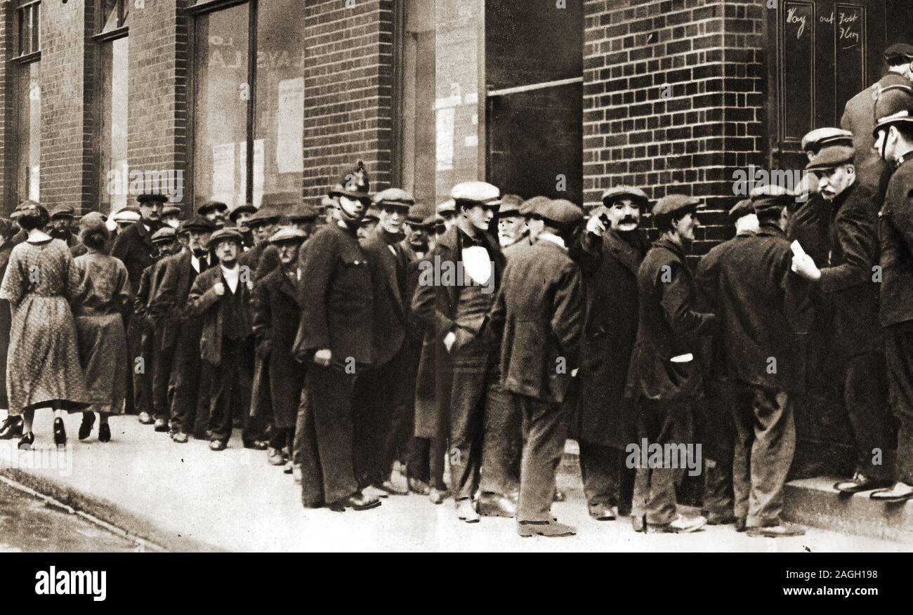 1922 - A queue of unemployed men  waiting to 'sign on'  for unemployment benefits  at a labour exchange in England This was as a result of The Unemployment Insurance Act 1920 to create dole (weekly cash unemployment benefits)   to unemployed workers. Stock Photo