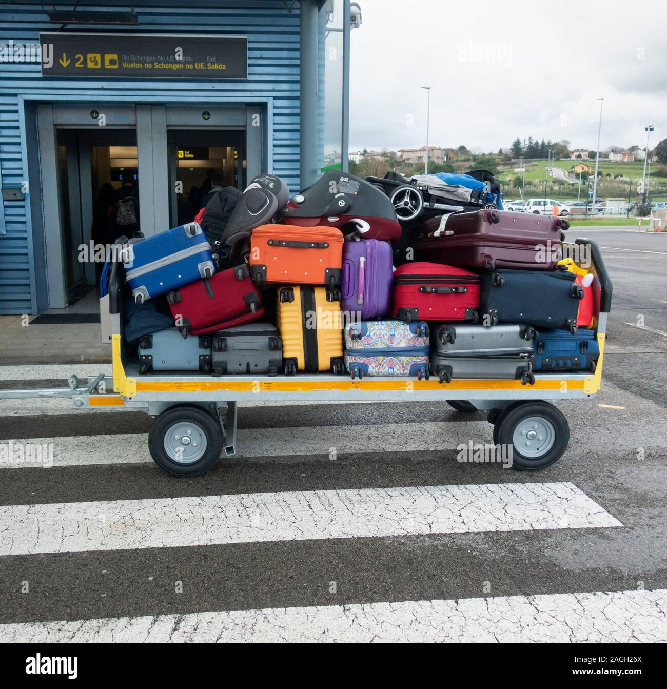 Suitcases, luggage loaded being taken to airport terminal from airplane. Stock Photo
