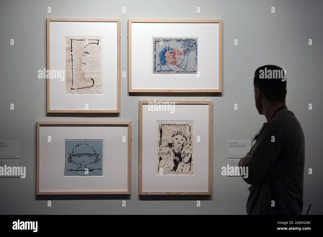 A worker looking at paintings and drawings during the exhibition.'Alechinsky: en el país de la tinta' (Alechinsky in inkland) is an exhibition of paintings and drawings by Belgian artist, Pierre Alechinsky at museum Centre Pompidou. The exhibition runs from 19th Dec 2019 to 12th April 2020. Stock Photo
