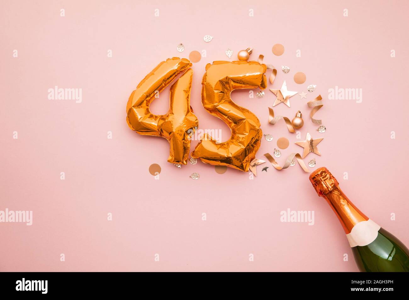 Happy 45th anniversary party. Champagne bottle with gold number balloon. Stock Photo