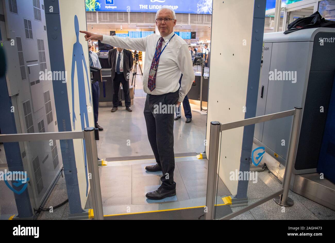 Munich, Germany. 19th Dec, 2019. Uwe Büchner, head of the department for air traffic safety in the Bavarian Ministry of Transport, is standing in front of a new body scanner at the security checkpoint. Transportation Minister Reichhart, (CSU) announced the first test results of the newly installed safety system in a press conference. Credit: Lino Mirgeler/dpa/Alamy Live News Stock Photo