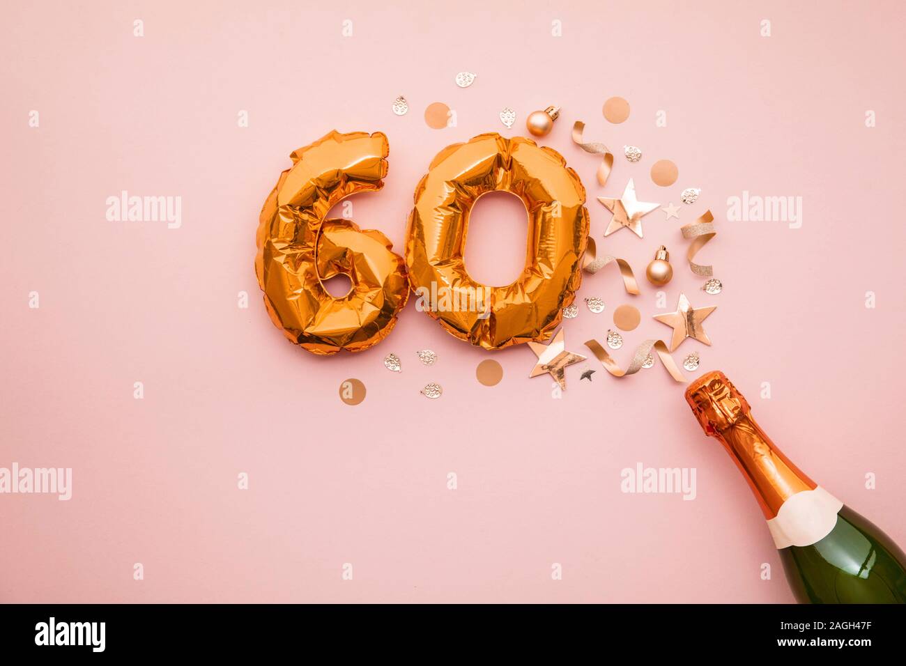 Happy 60th anniversary party. Champagne bottle with gold number balloon. Stock Photo