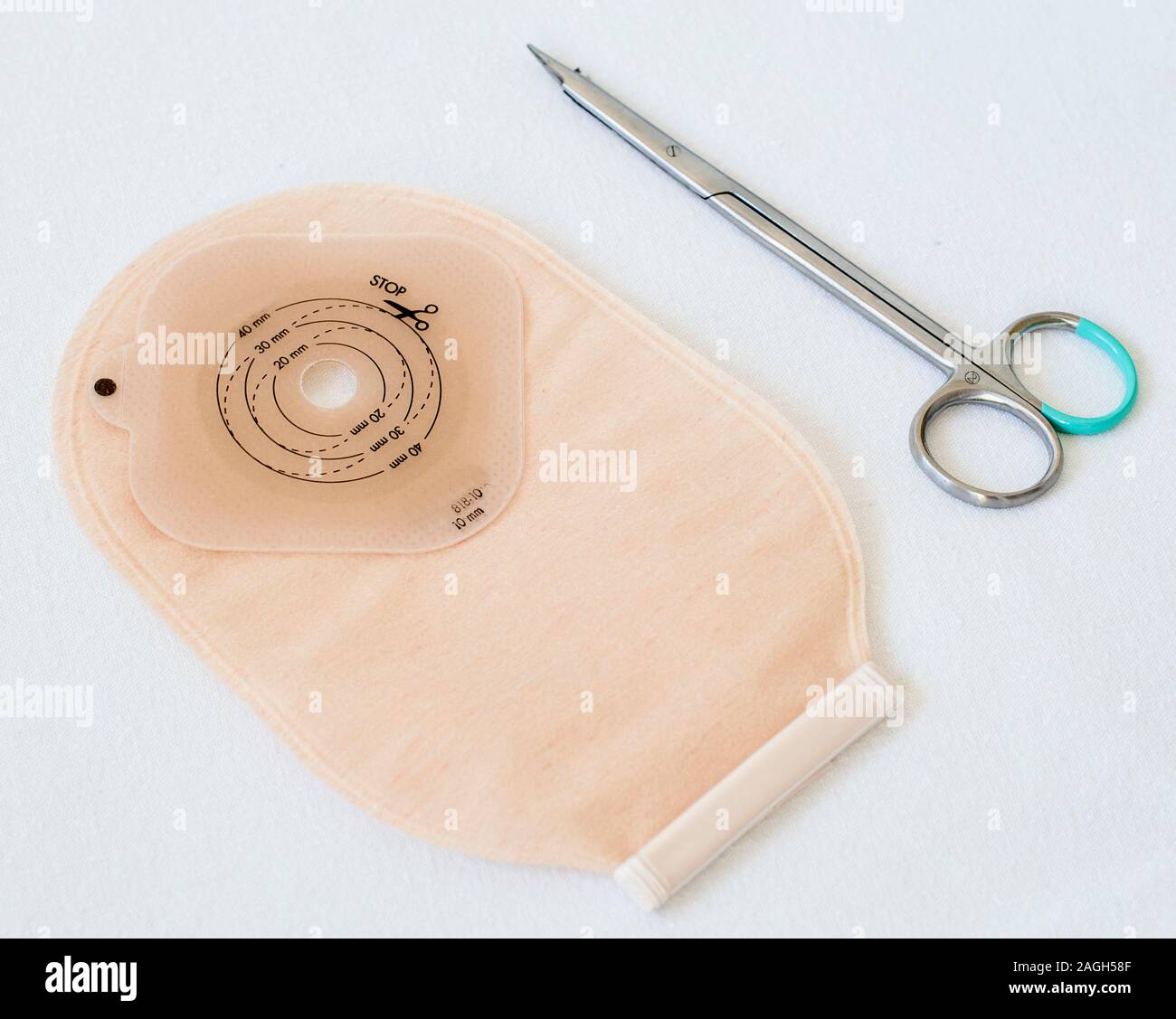 Top view on ostomy bag and scissors on white background. Closeup on