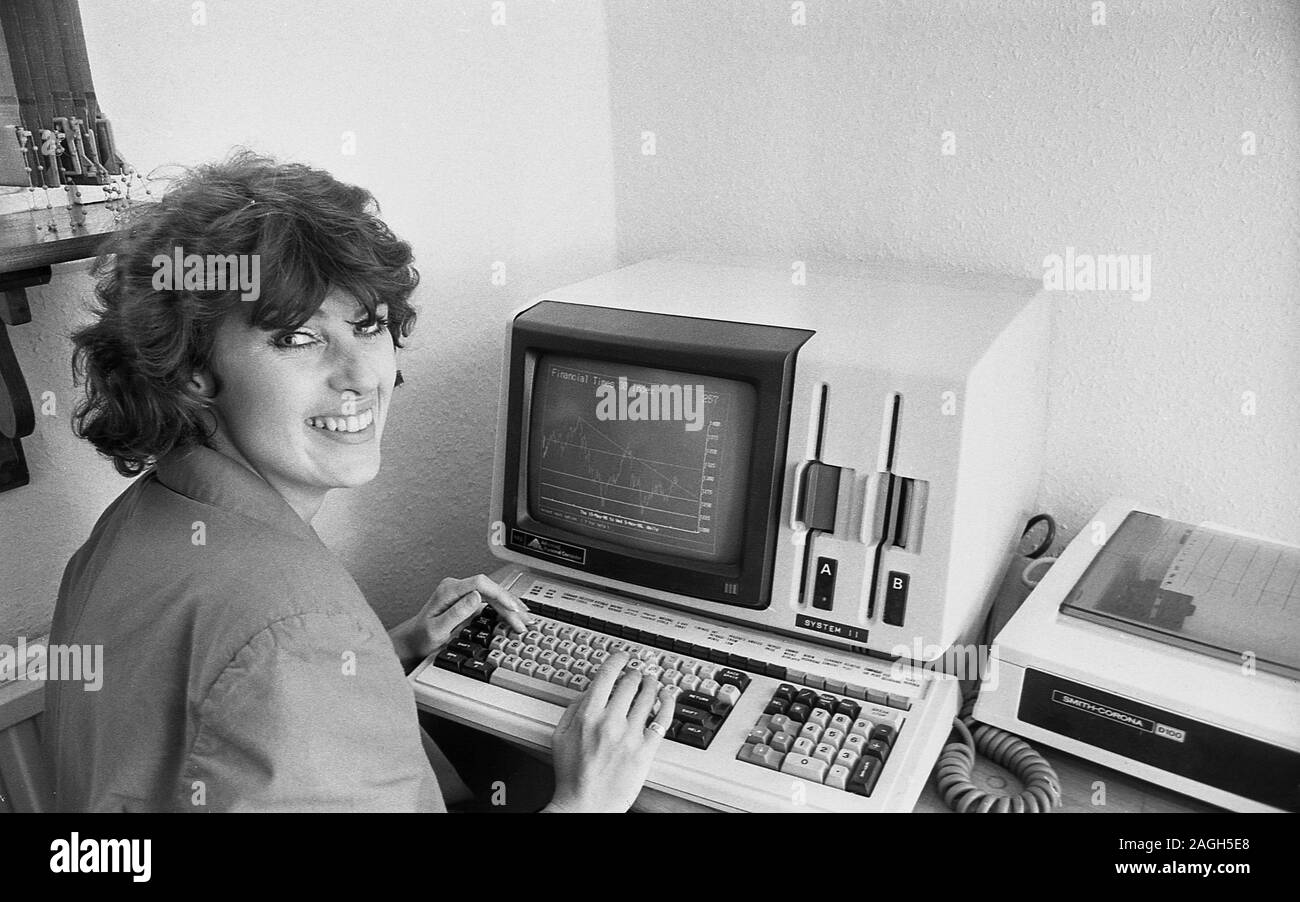 1980s, historical, a lady working at a keyboard and computer of the era, a NEC APC personal computer, a reliable business computer. Introduced in 1983, it ran on MS-DOS, from 8' floppy disks and was used in many businesses and financial institutions of the day for office administration. Stock Photo