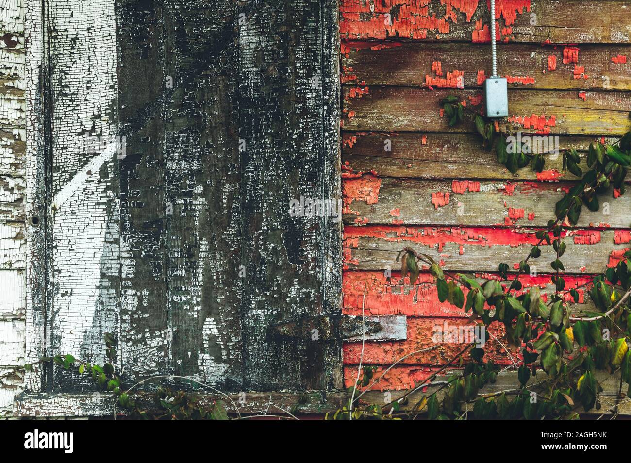 Wooden wall of an old abandoned house with the remainings of the red ...