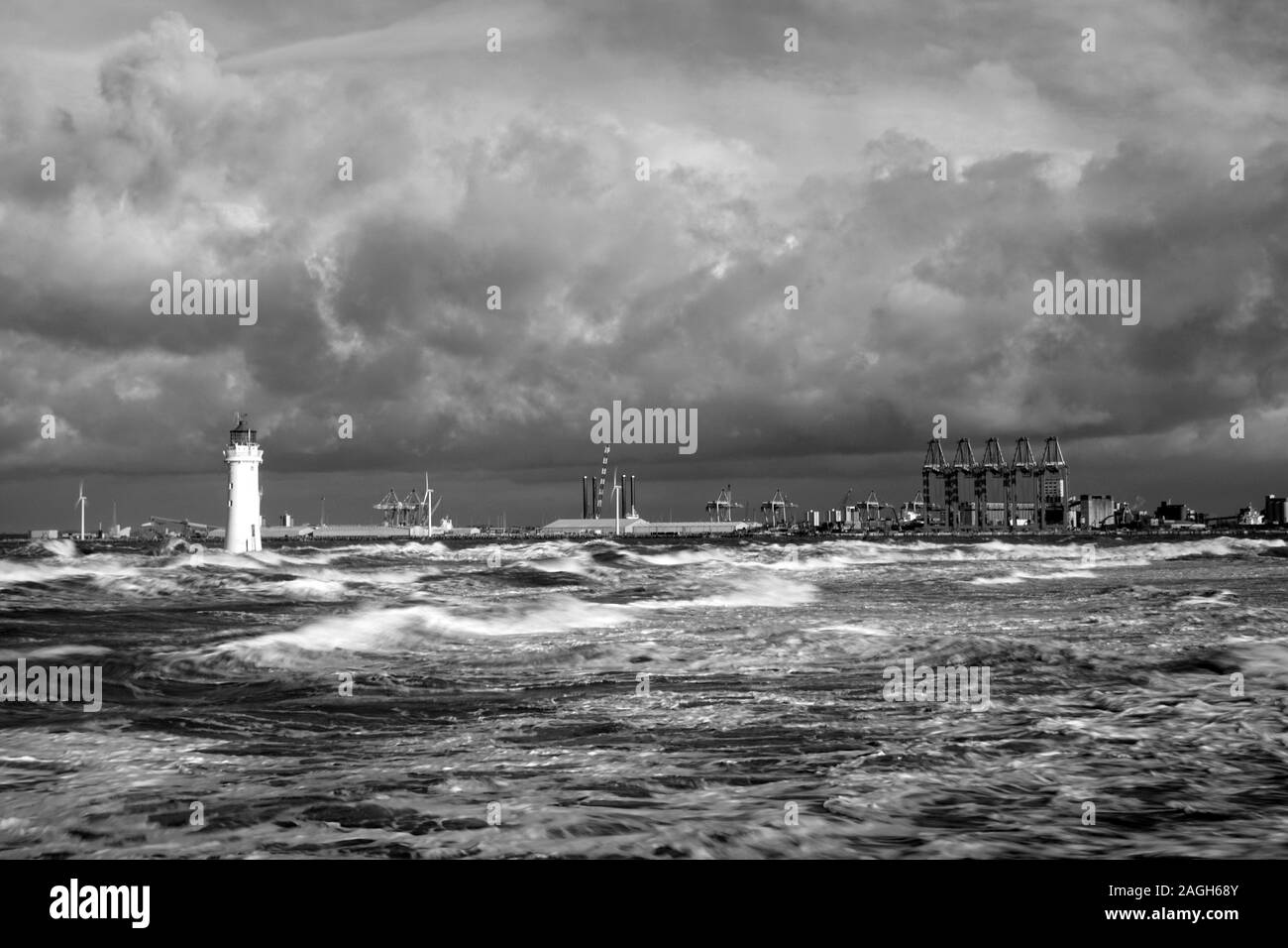 Greyscale of a sea with lighthouses and ships on it under a cloudy sky during daytime Stock Photo