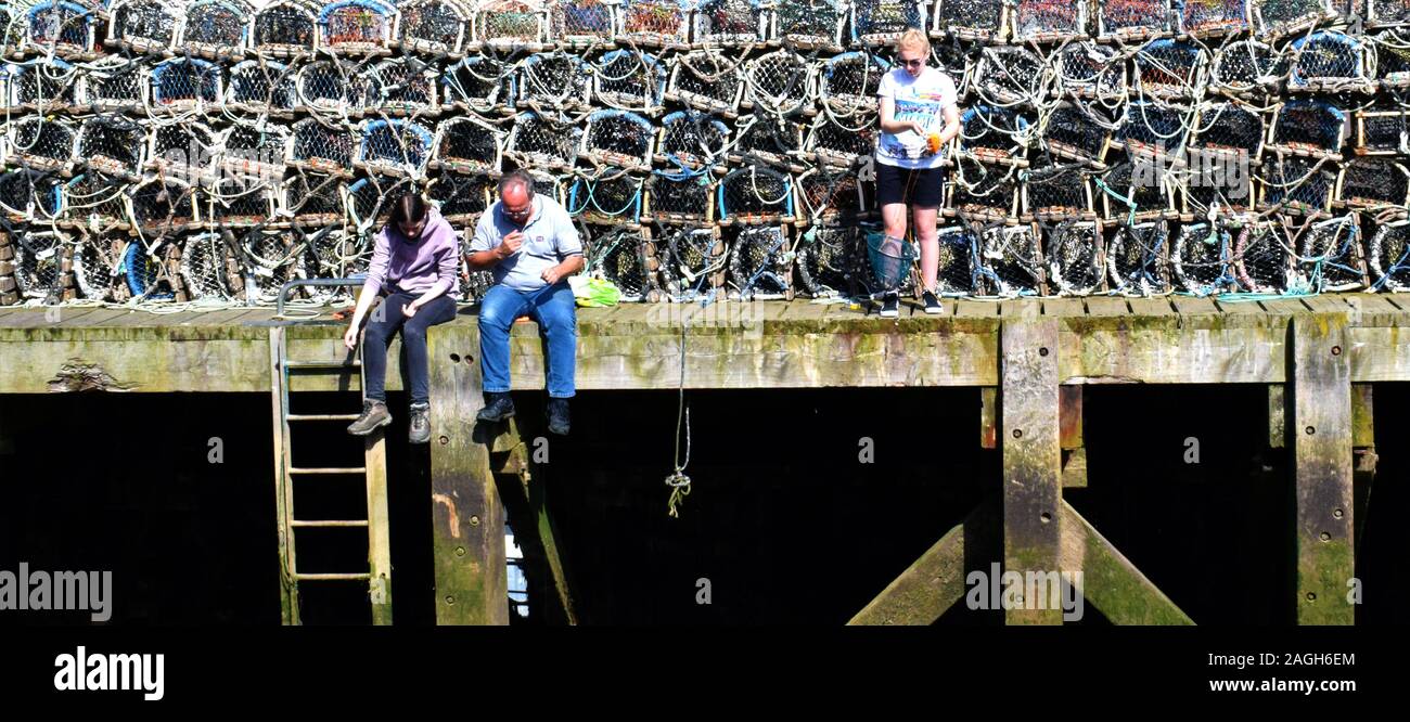 GONE FISHING Fishing with hand lines on the pier at Dock End, Whitby