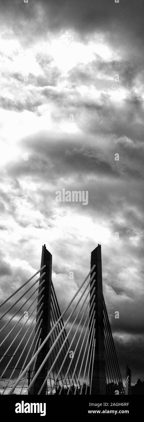 PORTLAND, UNITED STATES - Sep 20, 2019: A vertical greyscale shot of the St. Johns Bridge construction in Portland, Oregon under the dark cloudy sky Stock Photo