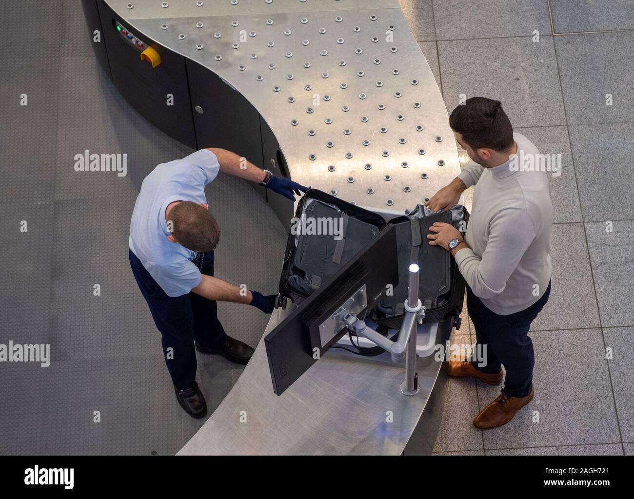 Munich, Germany. 19th Dec, 2019. A man's luggage is checked at the new security checkpoint by security personnel. Among other things, faster luggage and body scanners were installed at two security checkpoints. Transportation Minister Reichhart, (CSU) announced the first test results of the newly installed safety system in a press conference. Credit: Lino Mirgeler/dpa/Alamy Live News Stock Photo