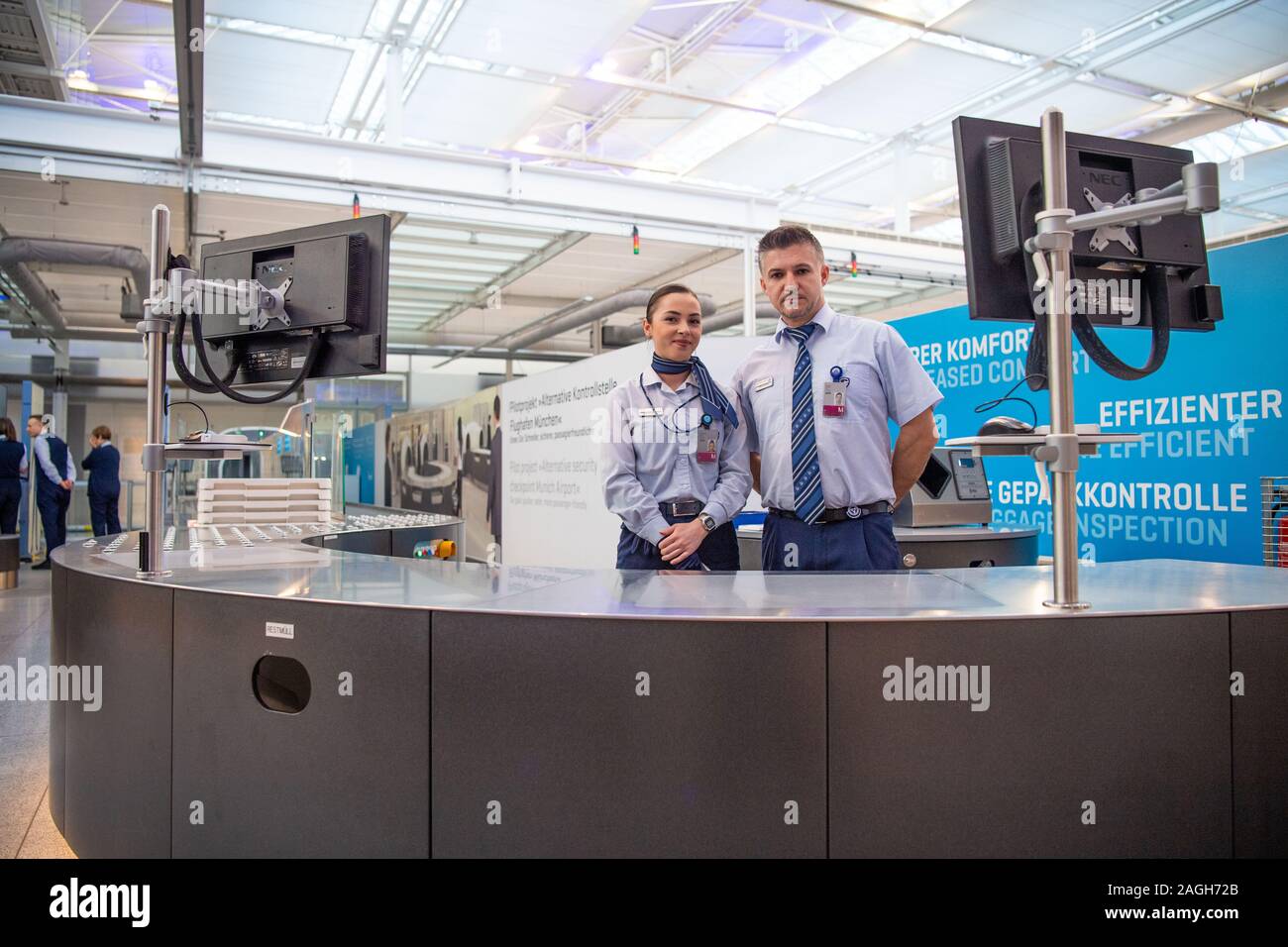 Munich, Germany. 19th Dec, 2019. Two security guards stand behind a counter at the baggage control desk during the press event for the new security check at Munich Airport. In a press conference, Transport Minister Reichhart (CSU) announced the first test results of the newly installed safety system. Credit: Lino Mirgeler/dpa/Alamy Live News Stock Photo