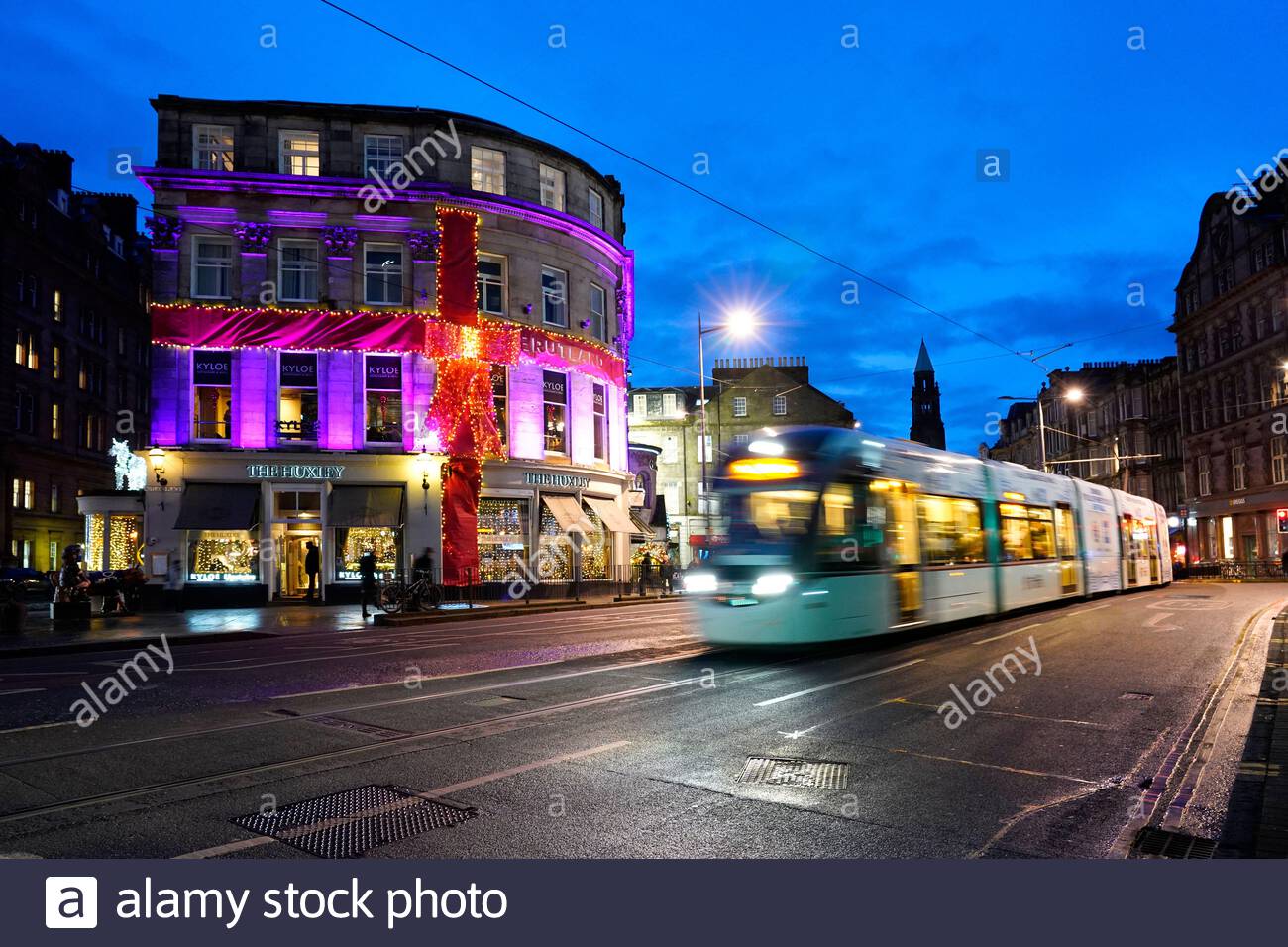 Edinburgh, Scotland, UK. 19th  Dec 2019. Dusk as a tram passes the Huxley bar and Restaurant decorated in Christmas lights in Shandwick Place in the West End. Credit: Craig Brown/Alamy Live News Stock Photo