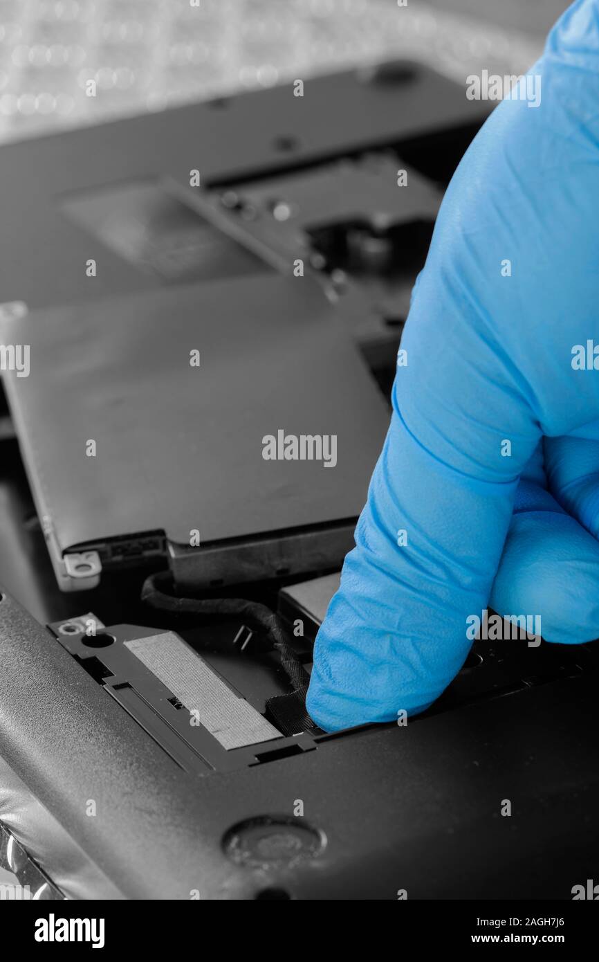 Technician connecting hard drive HDD cable to a laptop computer. Computer updrade concept Stock Photo