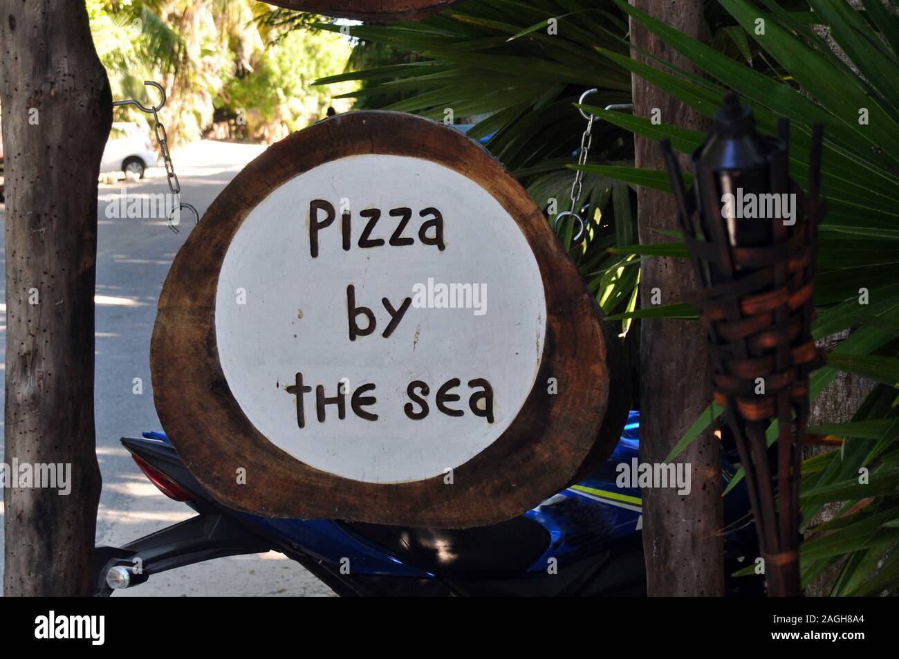 A Round Wooden Sign that says 'Pizza by the sea'. Stock Photo