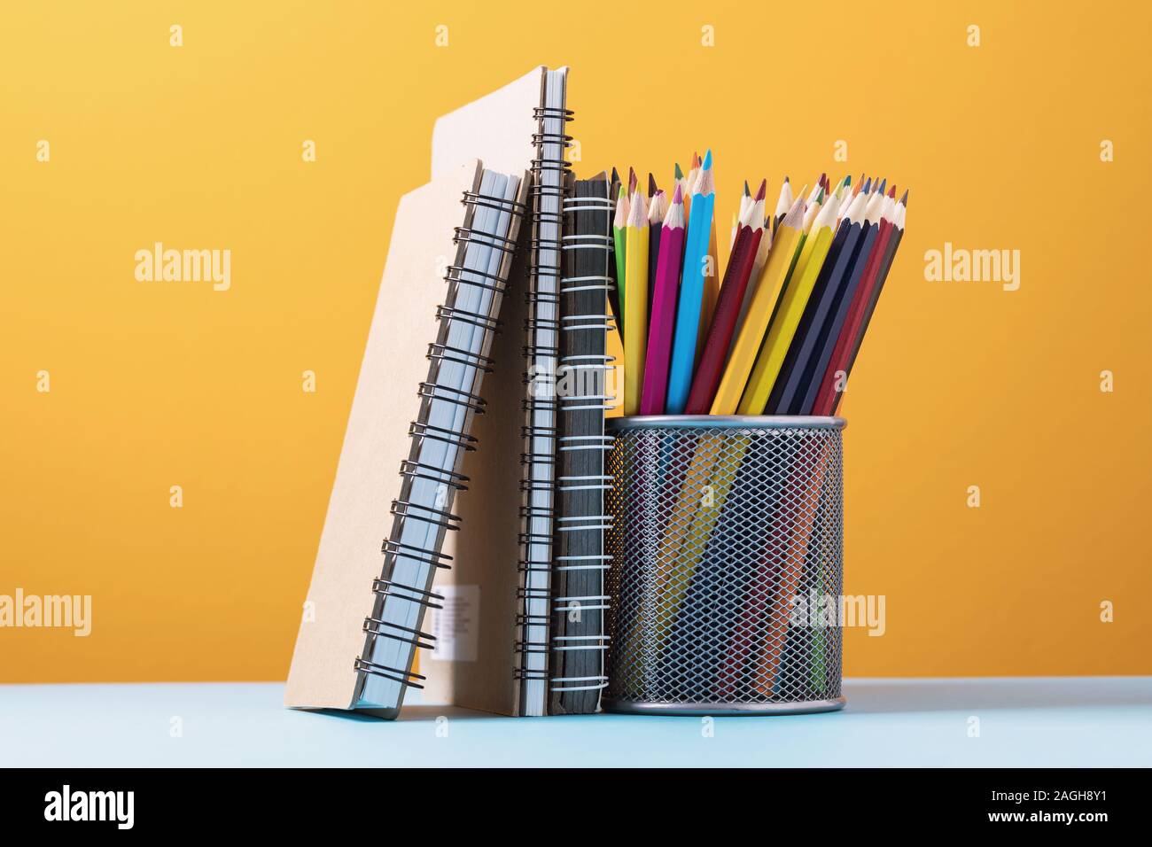 Various notebooks and pencils on a colored background Stock Photo
