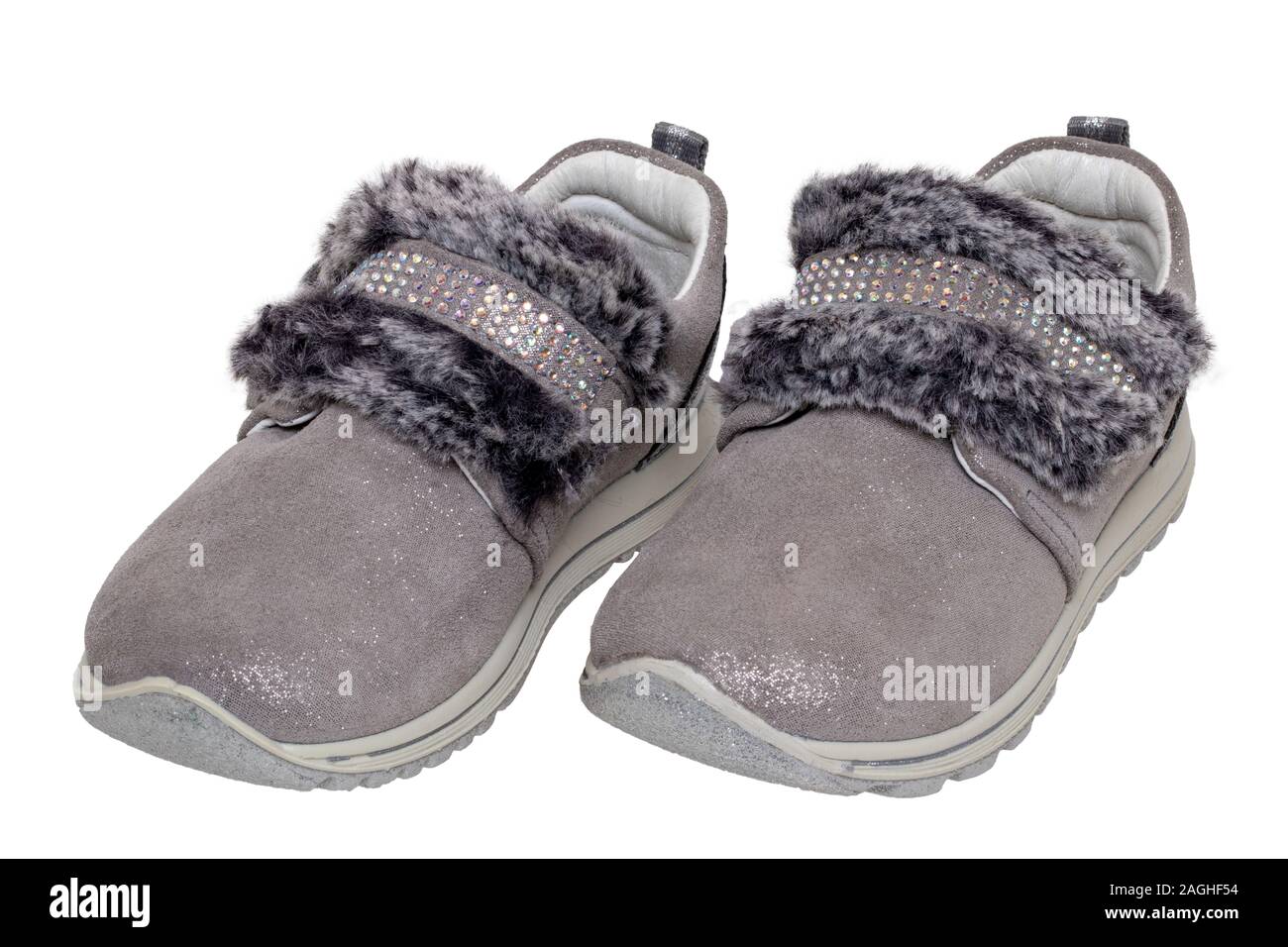 Child shoes fashion. Close-up of a pair beautiful gray silver suede sneaker or sports shoes for girls with fur and rhinestone decoration isolated on a Stock Photo
