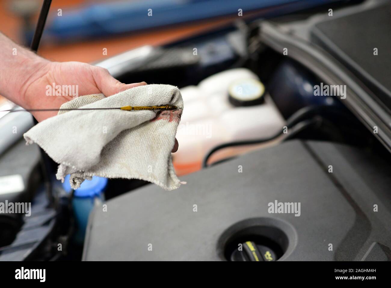 work-in-a-garage-worker-controls-and-changes-the-motoroil-stock-photo