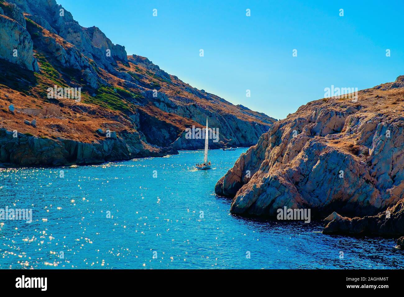 View of a sailing boat in the pass between Maïre island on the left and Cap Croisette, Marseilles France Stock Photo