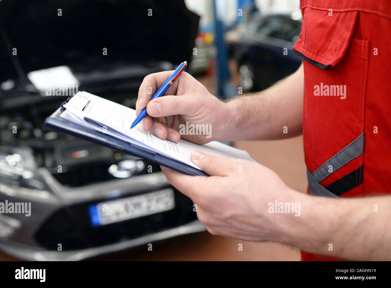 car mechanic in a with checklist engine repair and diagnosis