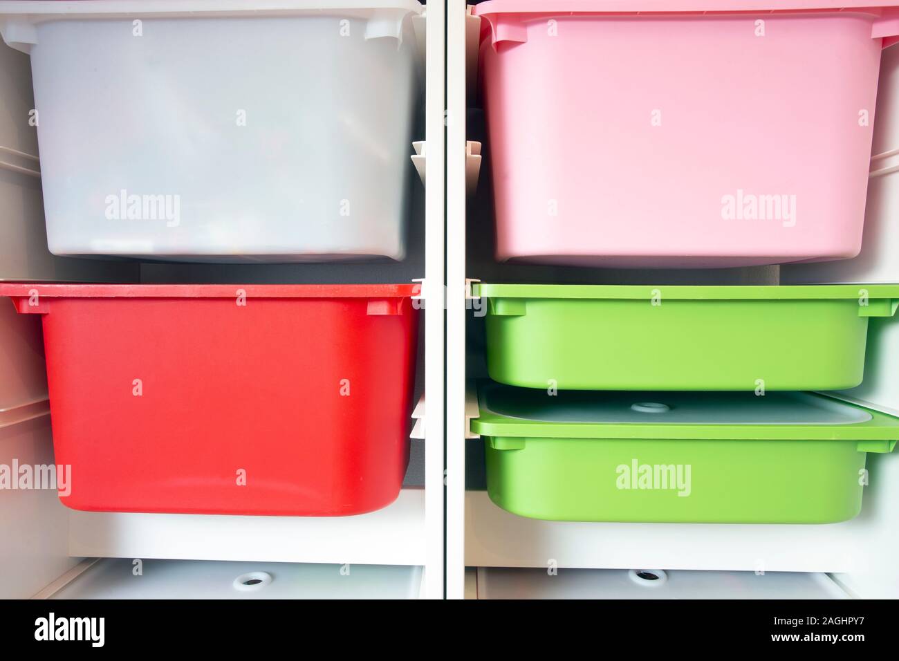 Stack of plastic storage boxes in different colors, sorting system arrangement Stock Photo