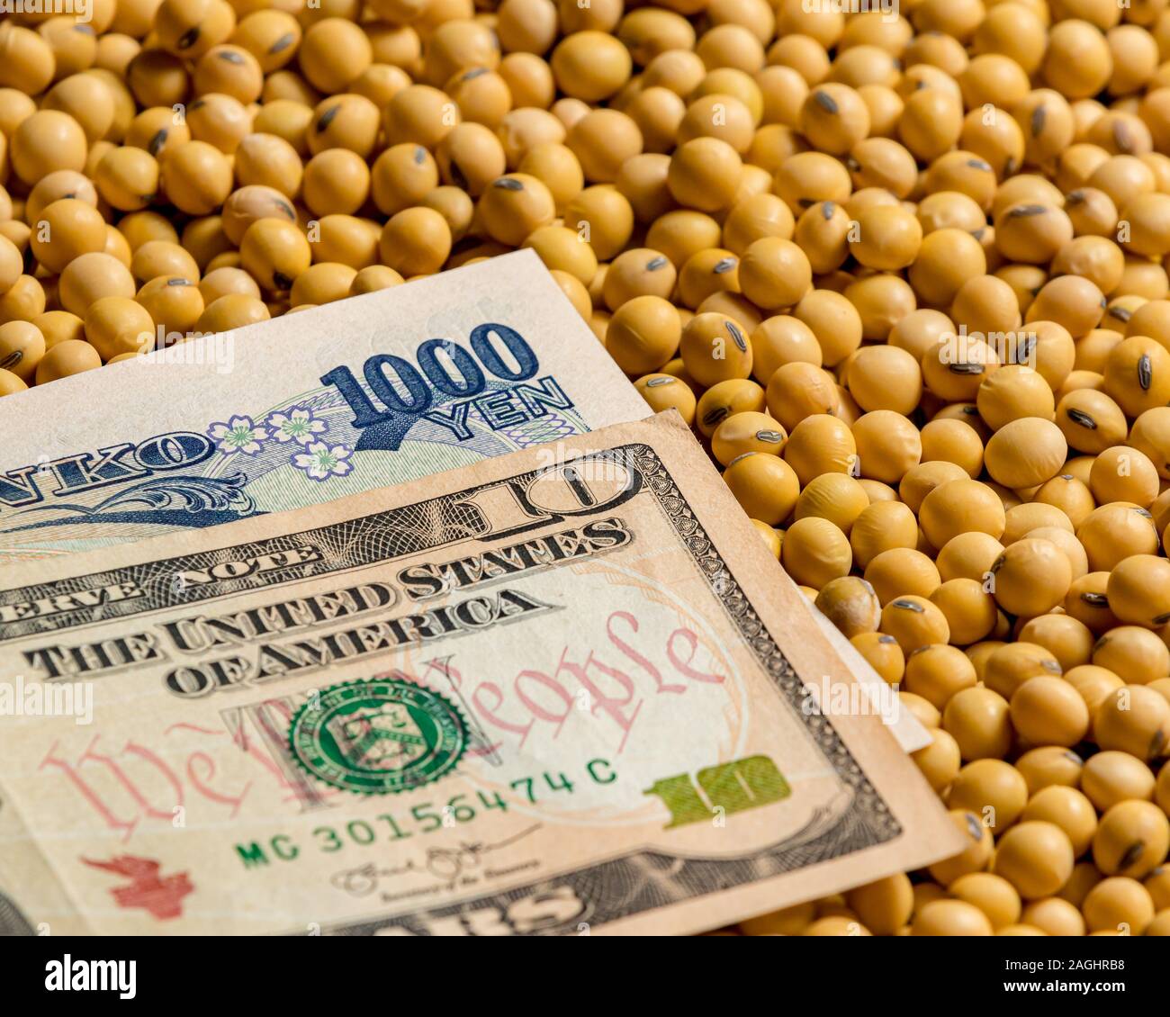 Japanese 1000 yen and American 10 dollar bill surrounded with soybean seeds. Concept of Japan and United States of America tariffs, trade agreement Stock Photo
