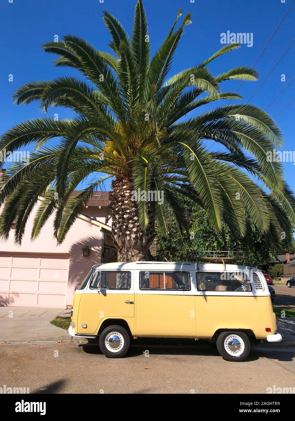 Classic beige and white vintage Volkswagen T1 camper van parked in front of pink house. San Diego, California, USA. July 13th, 2019 Stock Photo
