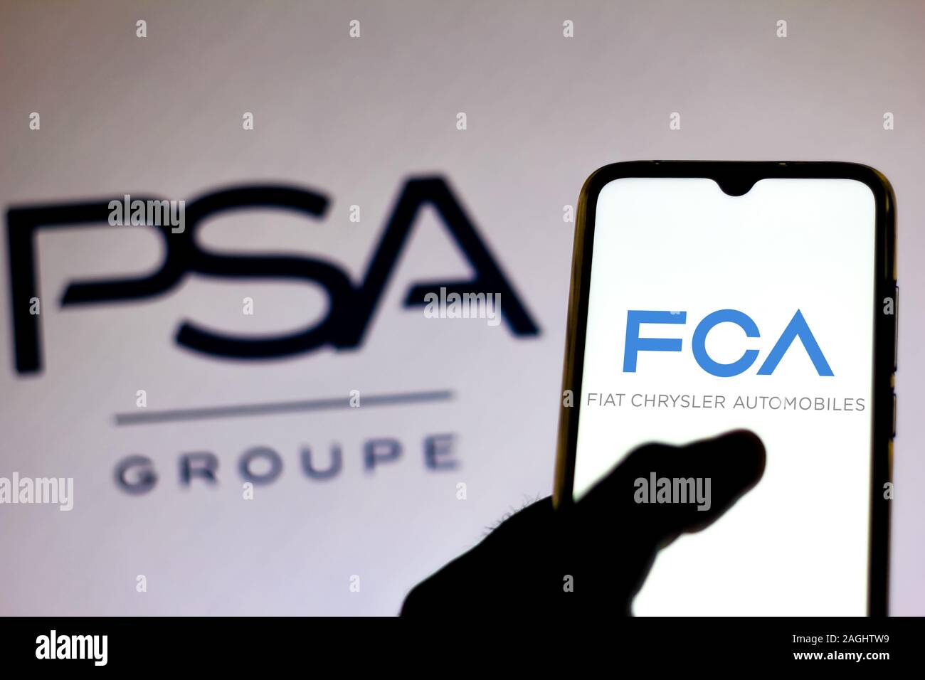 Brazil. 19th Dec, 2019. In this photo illustration the Fiat Chrysler Automobiles logo is viewed on a smartphone and Groupe PSA logo on a blurred background. Credit: Rafael Henrique/SOPA Images/ZUMA Wire/Alamy Live News Stock Photo