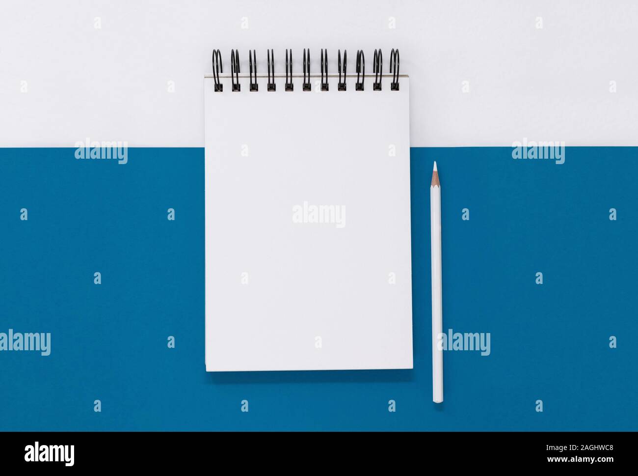 Open notepad and pencil on a blue and white background, with copy space ...