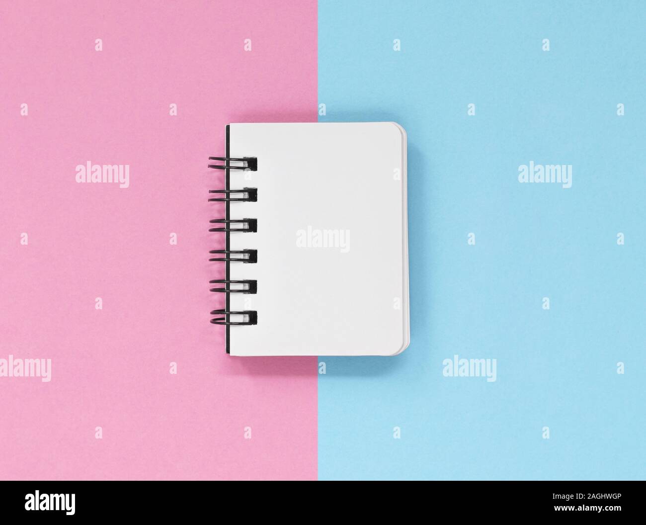 Open notebook pages on a pink and blue background, with copy space Stock Photo
