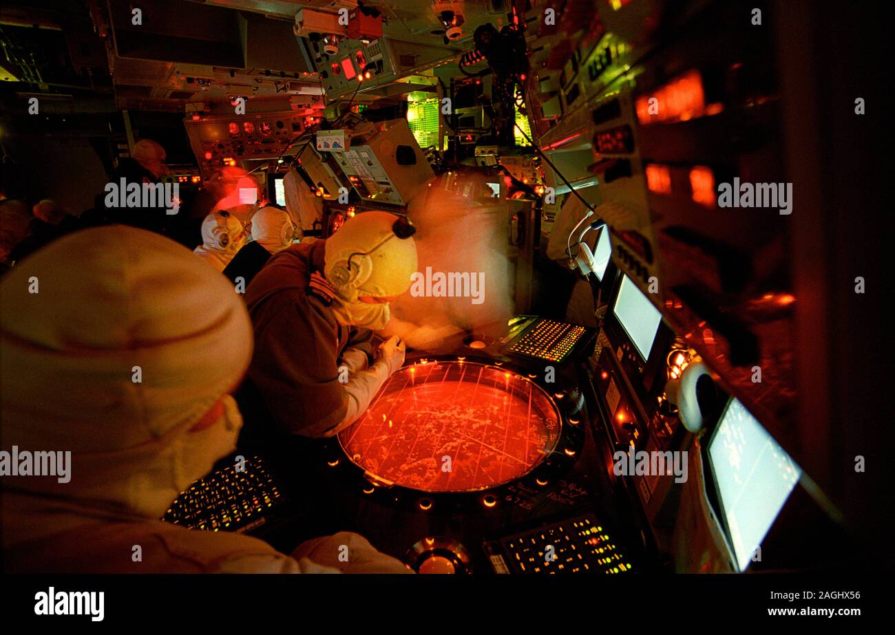 A Royal Australian Navy warfare officer and the Ops room crew of HMS Liverpool (D 92), a Royal Navy Type 42 Batch 2 destroyer, during an Air Raid Warning Red alert. They are using the Ferranti ADAWS 8 with ADIMP, interfacing with all weapons, sensors, ESM, radar and navigational equipment. Commissioned in 1982 she served with the RN until 2012 when she was paid off. Stock Photo