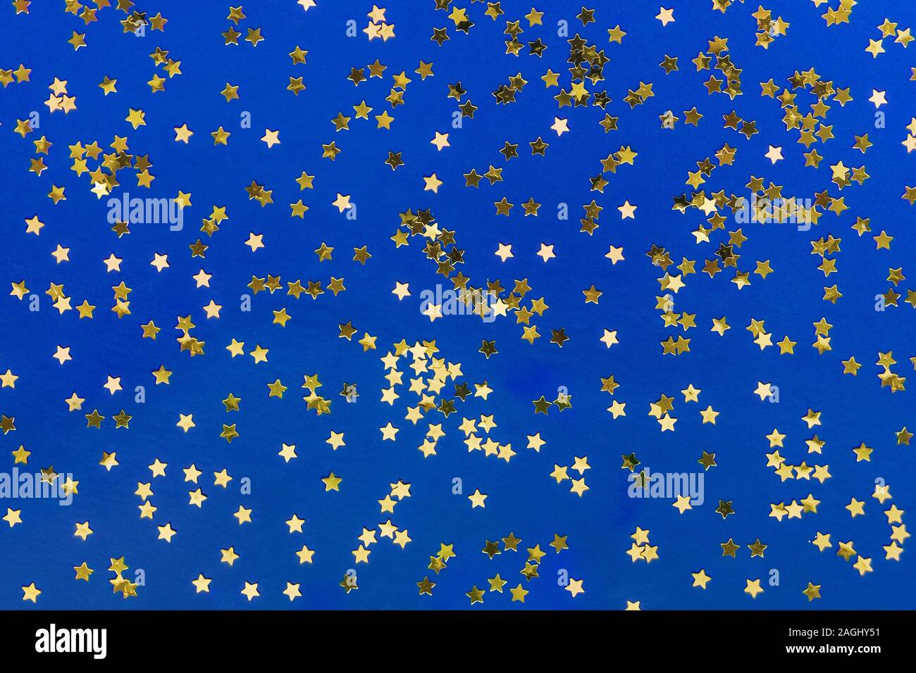 Delicate golden glitter star confetti on blue background. Creative and ...