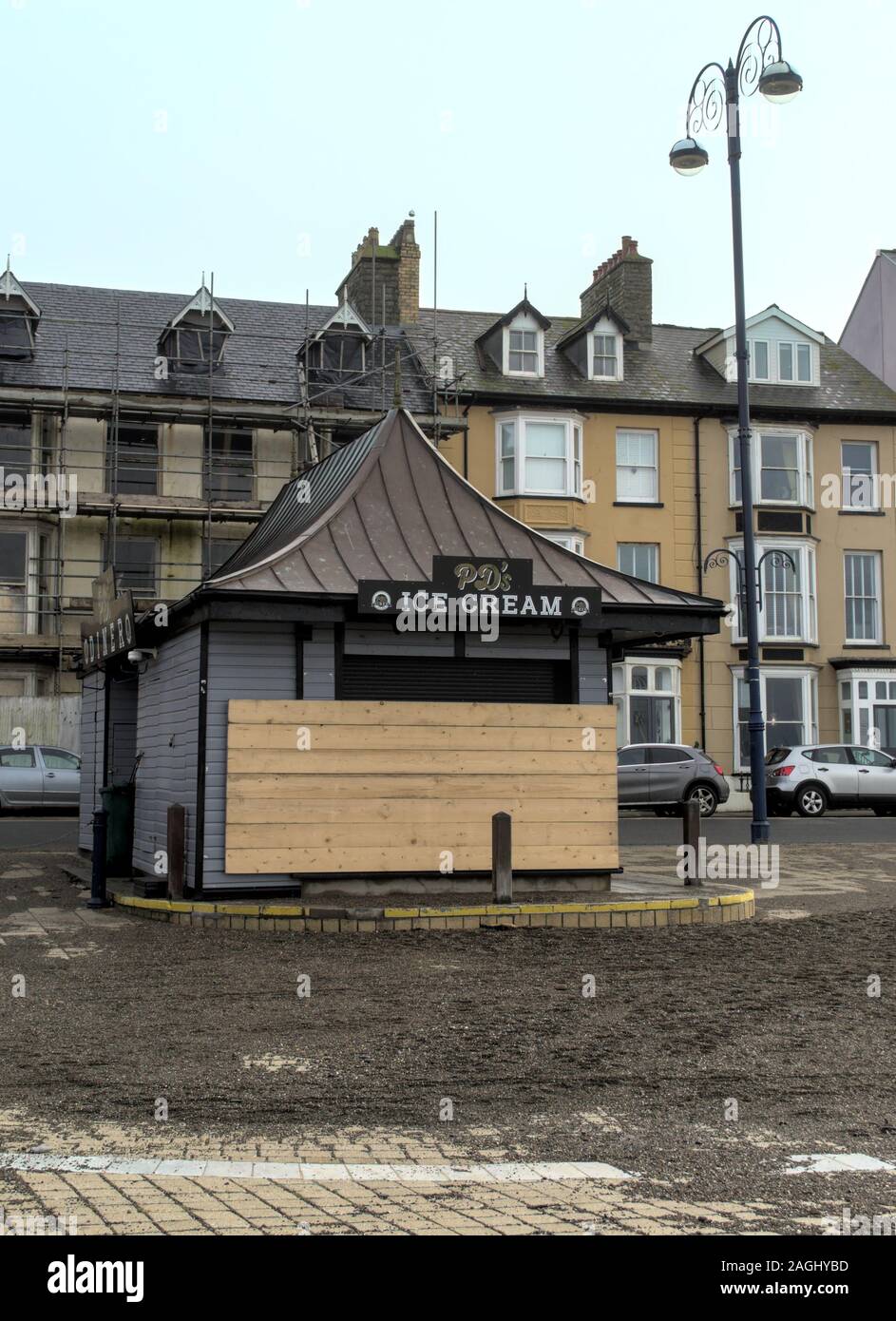 Local beach side cafe (PD Diner) boarded up as a defence against high tidal waves over the winter.  In front is sand washed ashore by recent storm Stock Photo