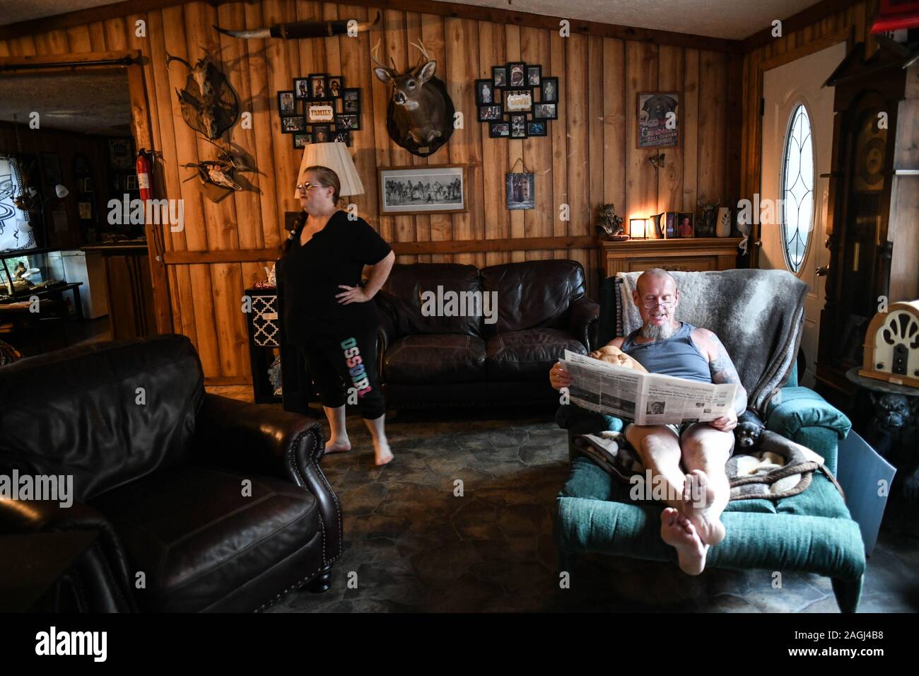 Dahlonega, Georgia, USA. 17th Sep, 2019. CHESTER DOLES reclines and reads in his living room with his wife, TERESA. His reading habits include the local newspaper, as well as white nationalist literature such as 'The Conservative Action Report, ' and the Temple of Wotan. He also treasures 'The Holy Book of the Aryan Tribes' by Ron McVan, which is wrapped in a leather cover Doles carved with the title, 'Doles Family Odins Folk.' Credit: Miguel Juarez Lugo/ZUMA Wire/Alamy Live News Stock Photo