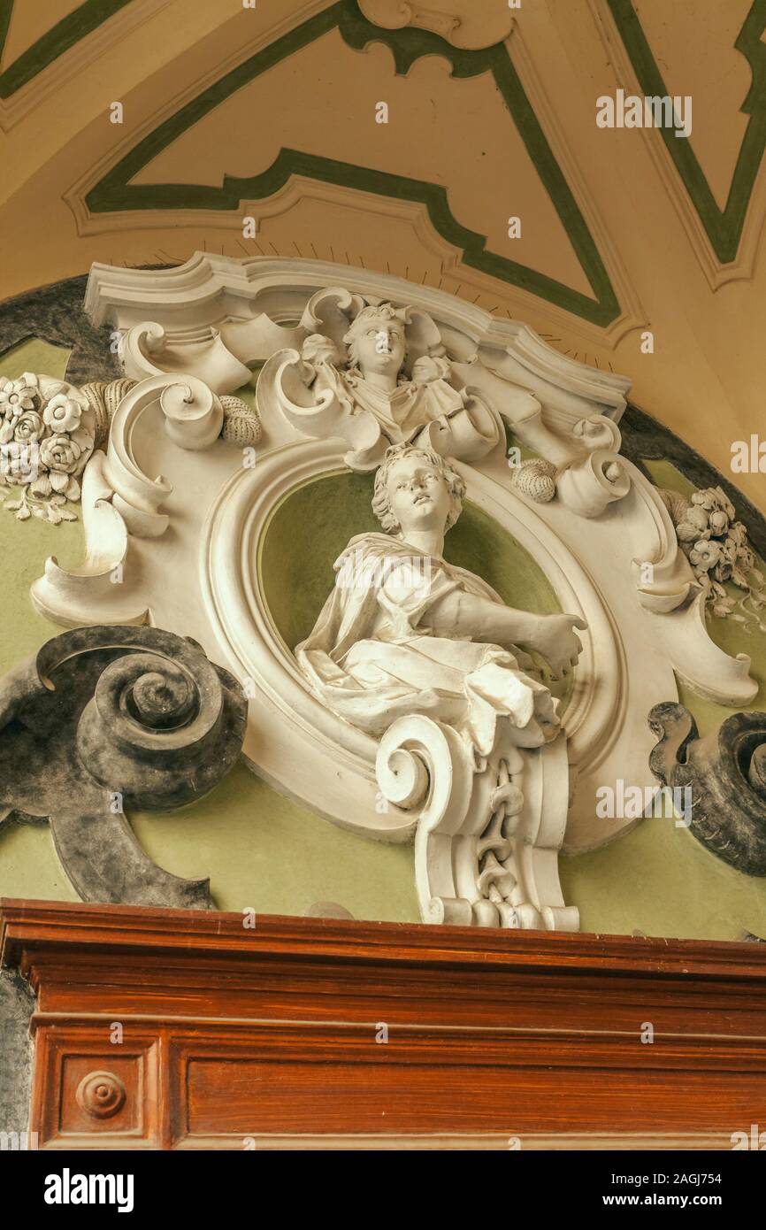 Entrance door decorate with sculpture in the famous double-flight staircase of the Palazzo dello Spagnolo, Naples, designed by the Baroque architect F Stock Photo