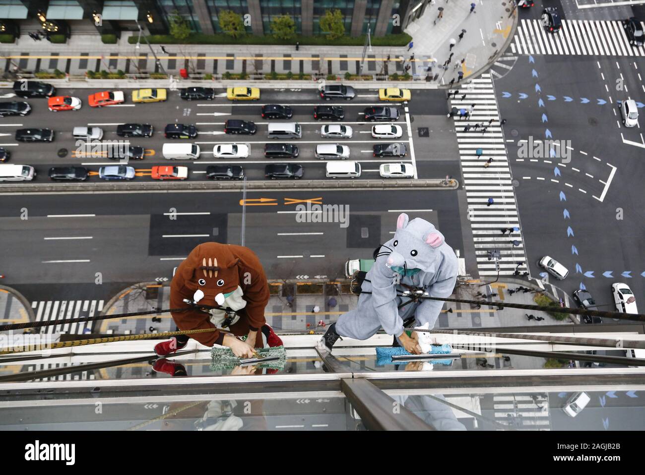 Tokyo, Japan. 19th Dec, 2019. Window cleaners dressed as a wild boar ...