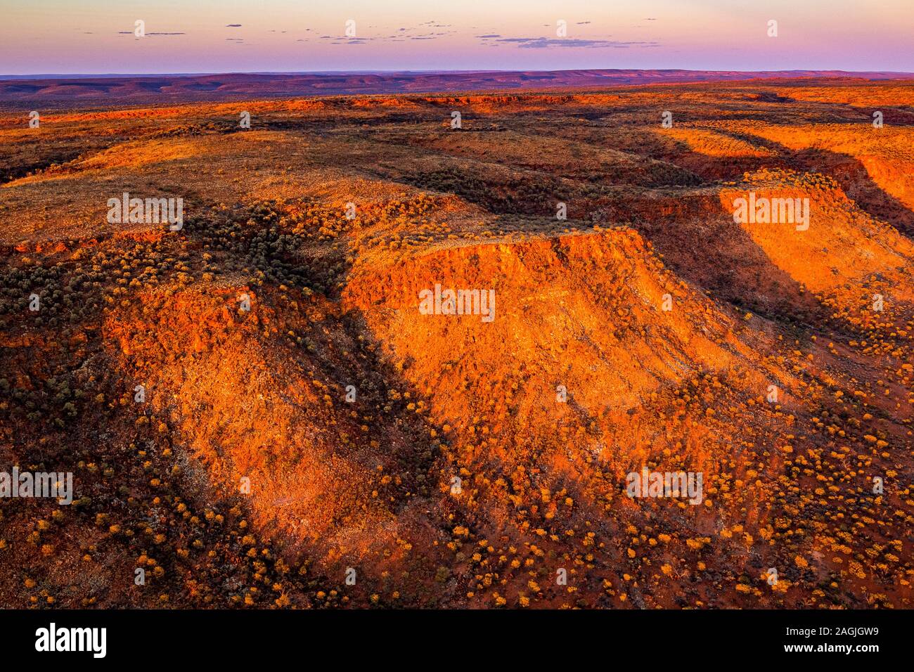 A remote Australian desert sunset near Kings Creek in central Australia. The George Gill Ranges dominate the landscape. Stock Photo