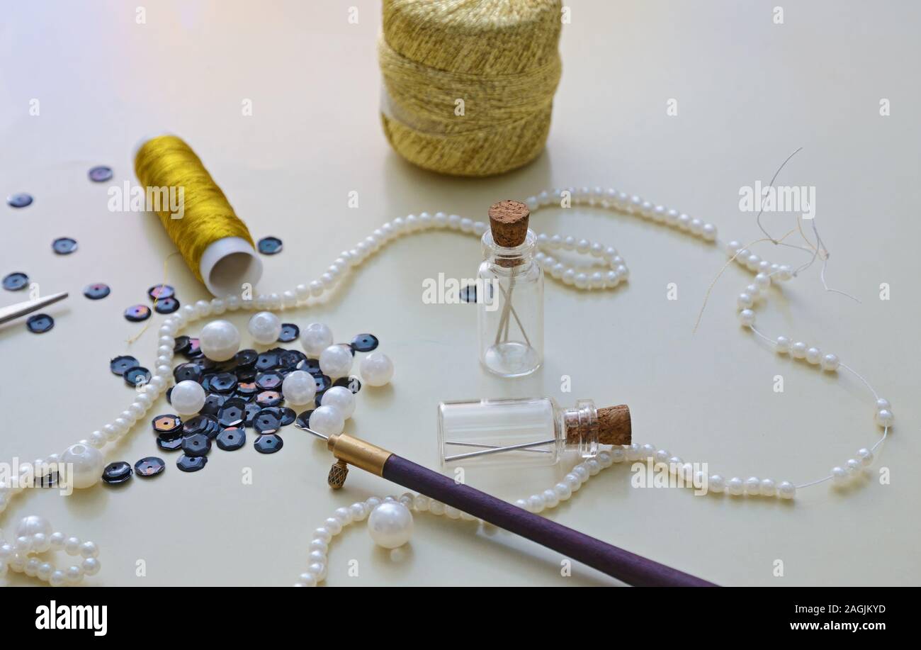 Hook, metallic fibers, scissors, pearl beads, sequins and other supplies for bead embroidery or Luneville embroidery Stock Photo