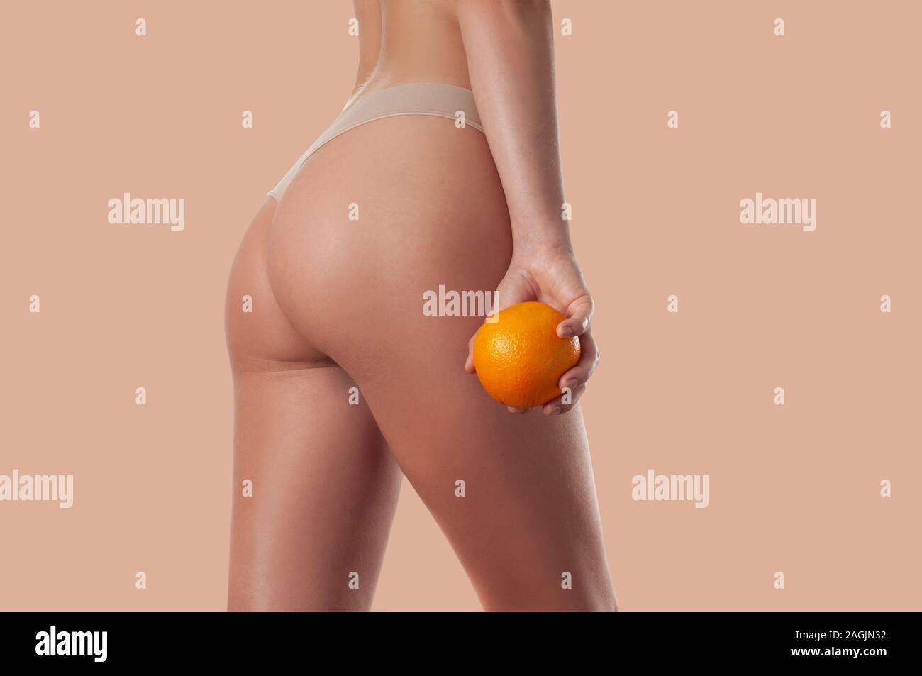 Slim woman is holding orange. Perfect female buttocks without cellulite.  Beautiful woman's butt in underwear. Body care and anti cellulite massage  Stock Photo - Alamy