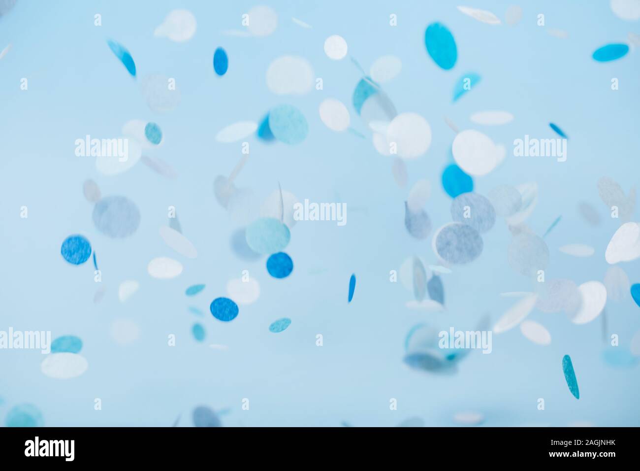 Blue falling confetti on pastel blue background Stock Photo - Alamy