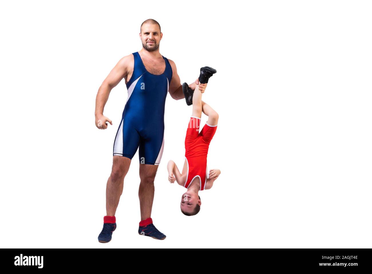 Men in wrestling tights and wrestlers holds the foot of a wrestler