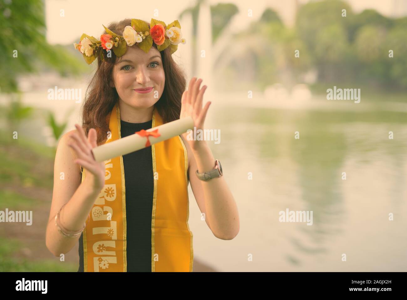 Young beautiful woman celebrating graduation at the park in Bangkok, Thailand Stock Photo