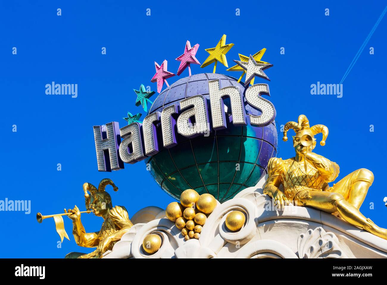 Two gilded jester, joker sculptures blow trumpets seating between globe and stars, and on outdoor marquee of Harrah's casino and hotel - Las Vegas, Ne Stock Photo