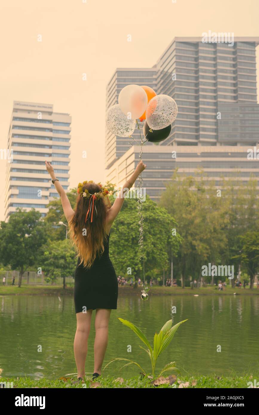 Young beautiful woman celebrating graduation at the park in Bangkok, Thailand Stock Photo