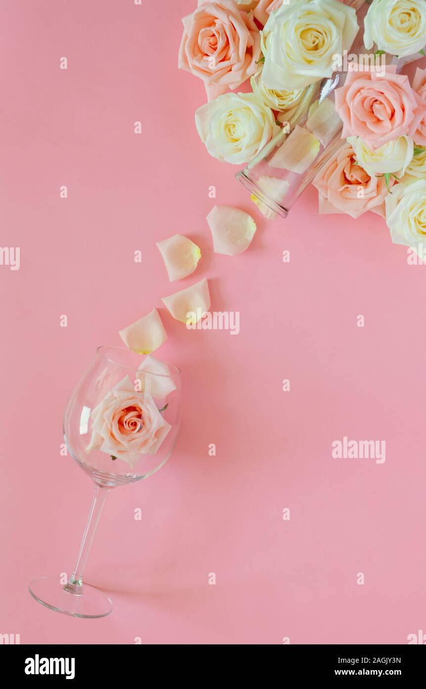 Pink rose in wine glass with the petals from the bottle put on pink