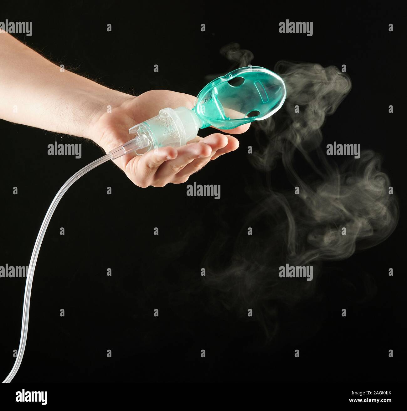 Working inhaler in hand with smoke isolated on black background Stock Photo