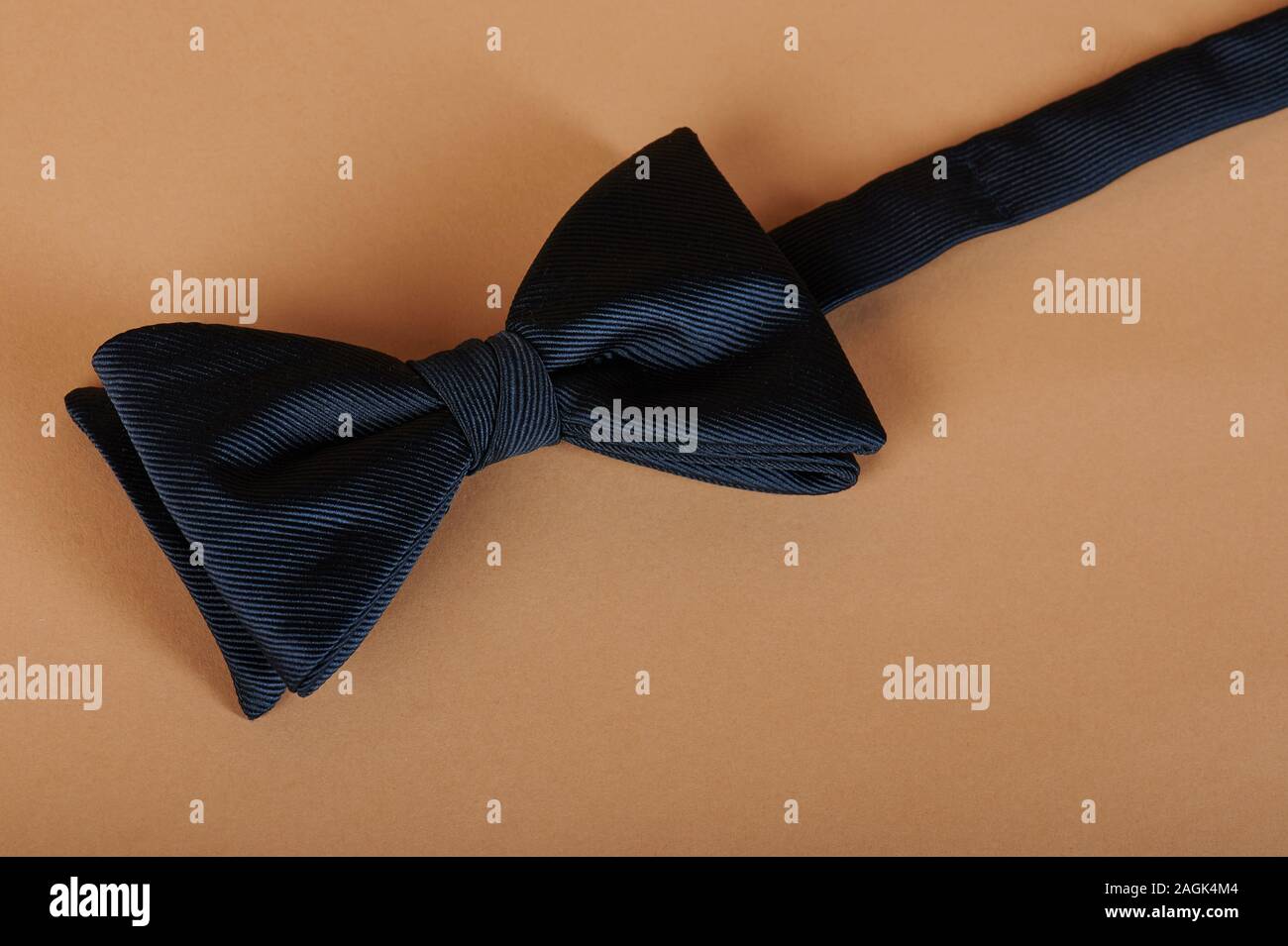 Blue bow tie on beige color background close up view Stock Photo