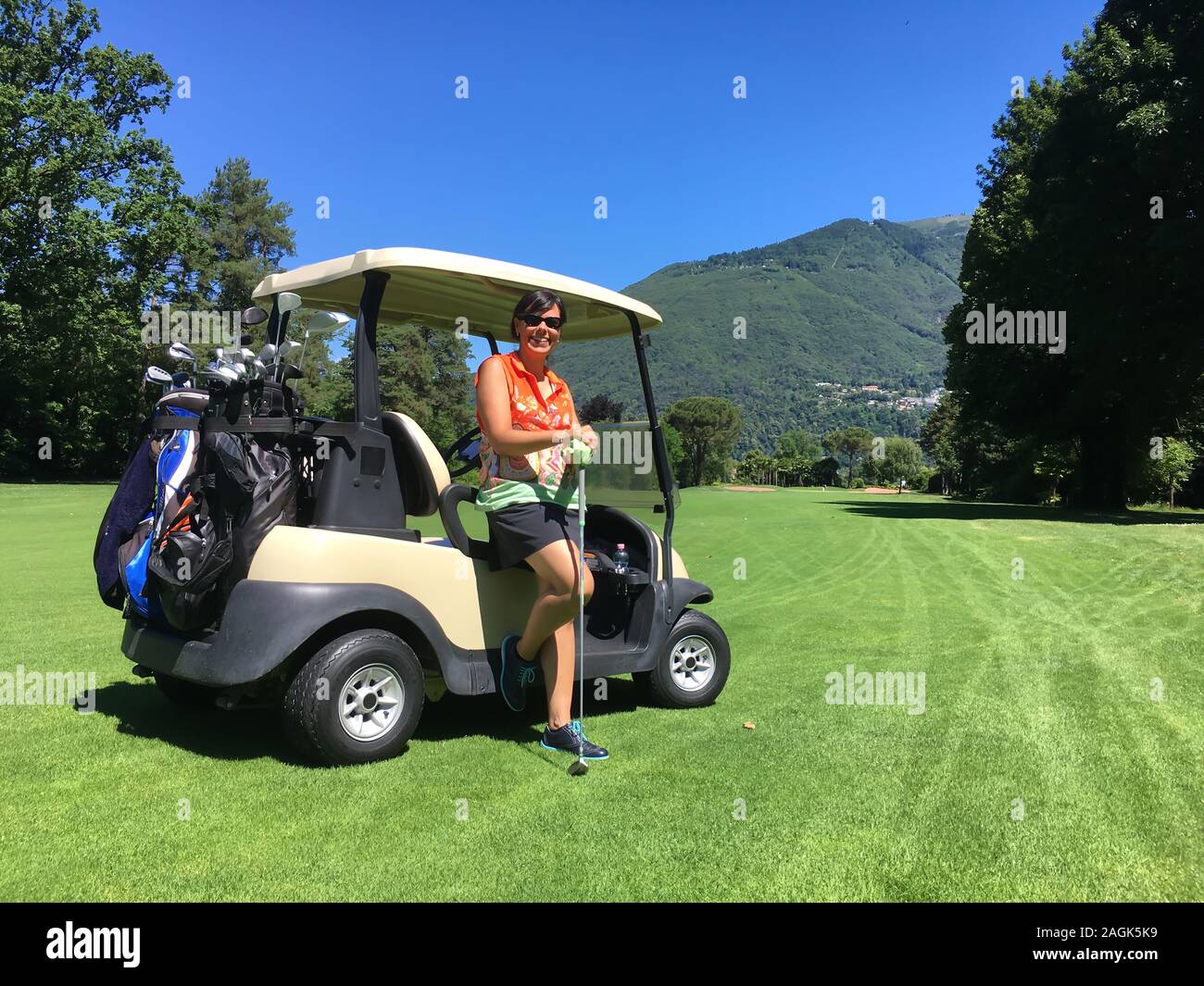 Woman Leaning on a Golf Cart on the Fairway with Mountain in Background in  a Sunny Day in Switzerland Stock Photo - Alamy