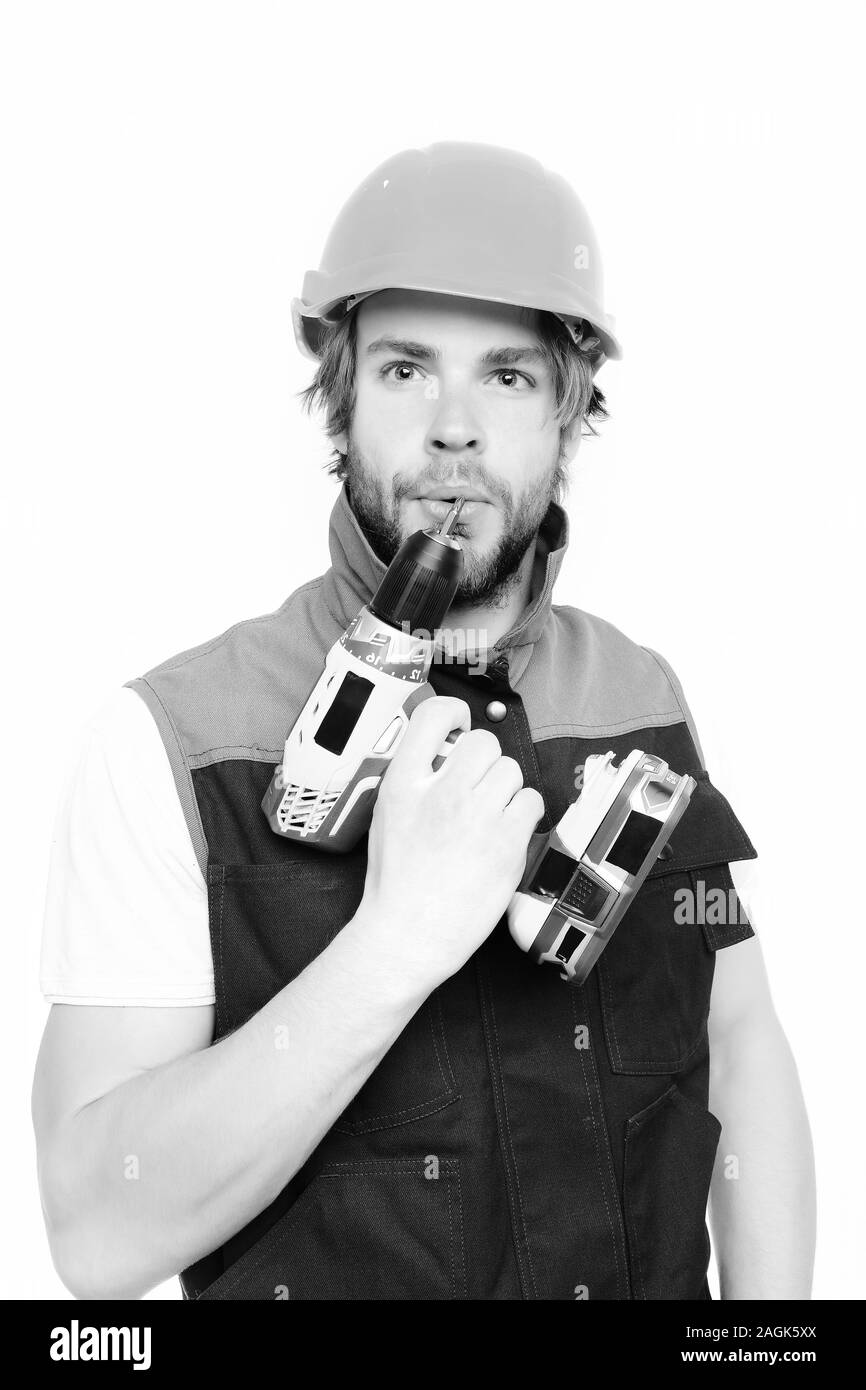 Contractor and tool. Yellow electric screwdriver in hand of concentrated and thoughtful builder, isolated on white background. Concept of finished work and professional skills Stock Photo